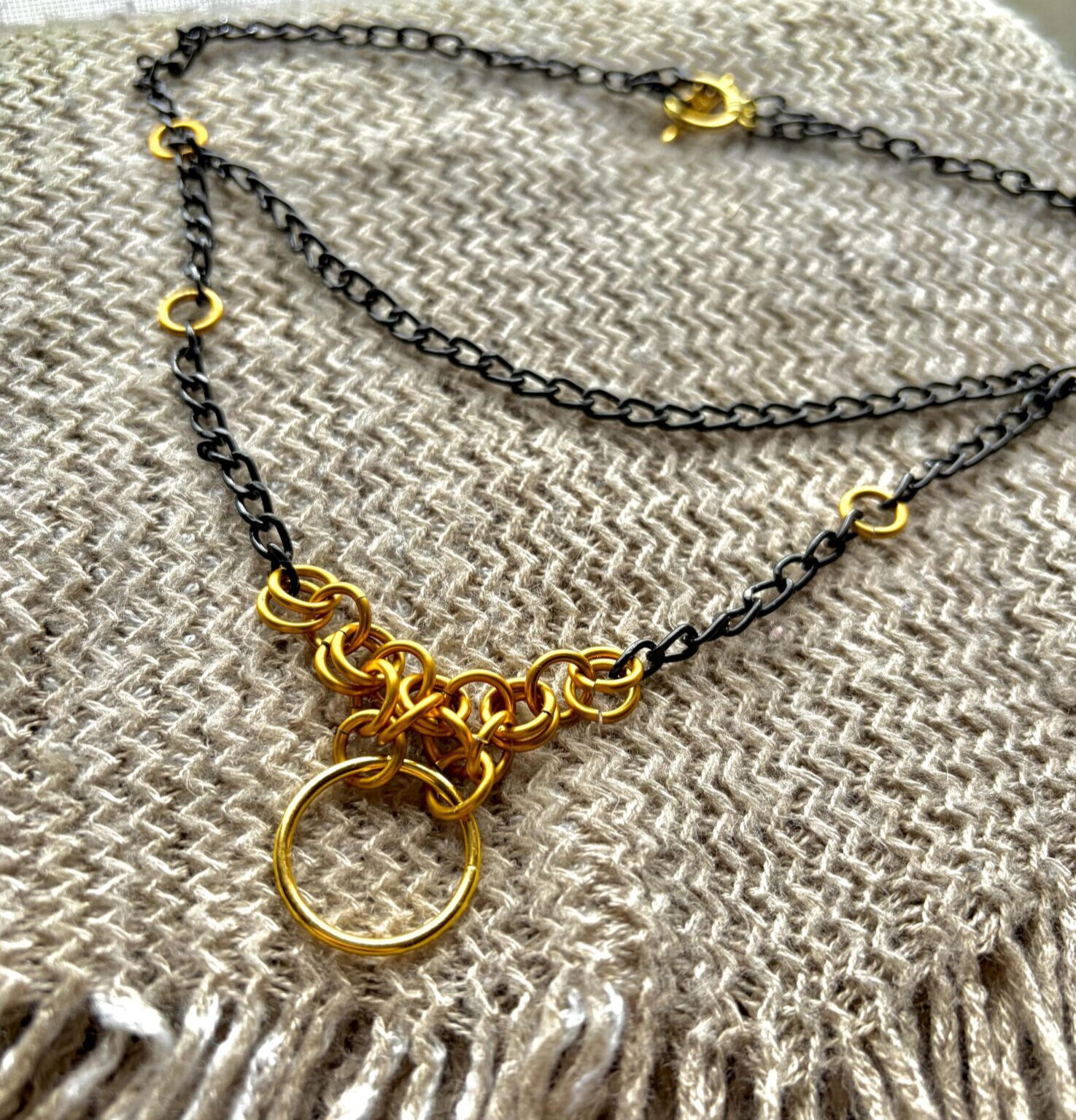 customnecklace Image of a necklace with black chain and gold jumpring accents.
